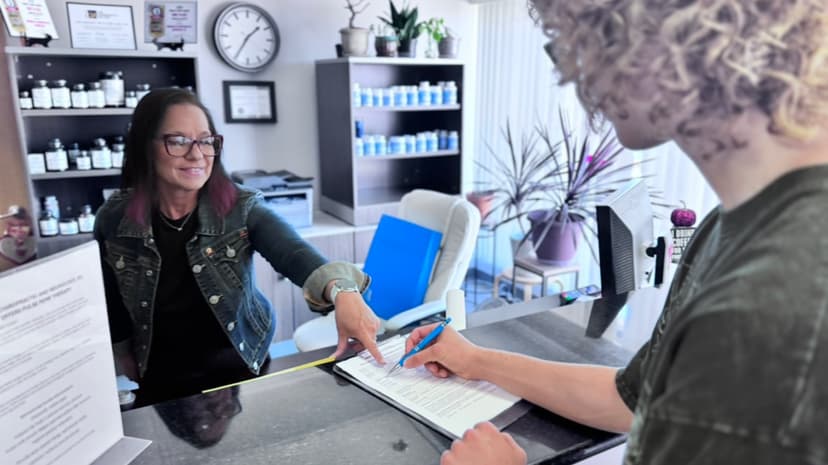 Jamie helping a patient with paperwork at the front desk of Advanced Chiropractic and Neurology in La Vista, NE